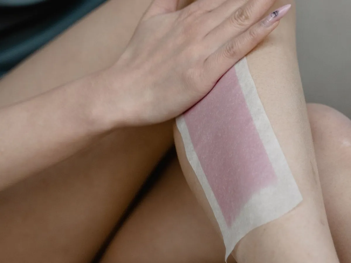 A wax strip on a woman’s leg during waxing